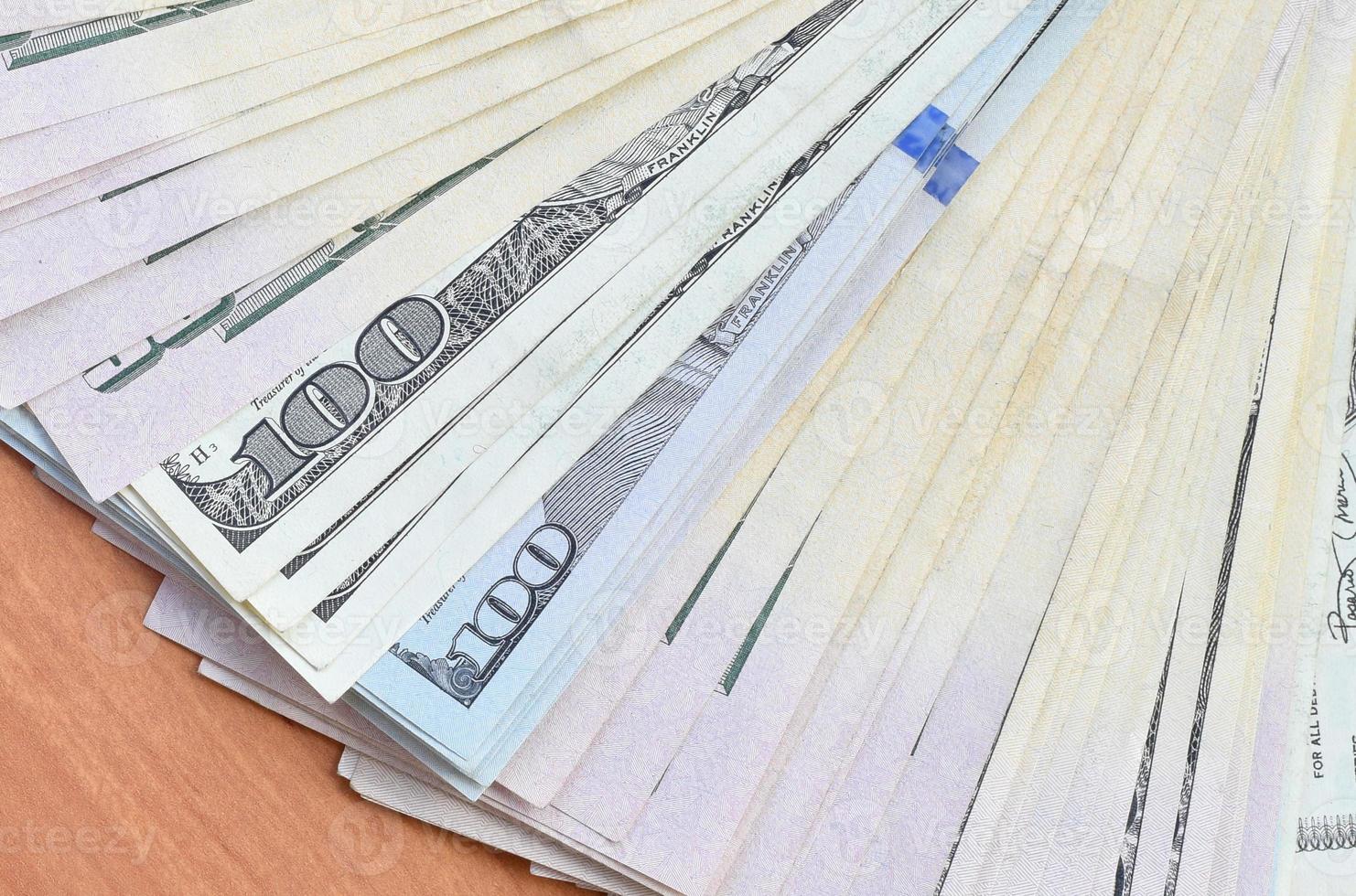 Fan of many one hundred and fifty dollar bills on wooden background surface close up. Flat lay top view. Abstract business concept photo