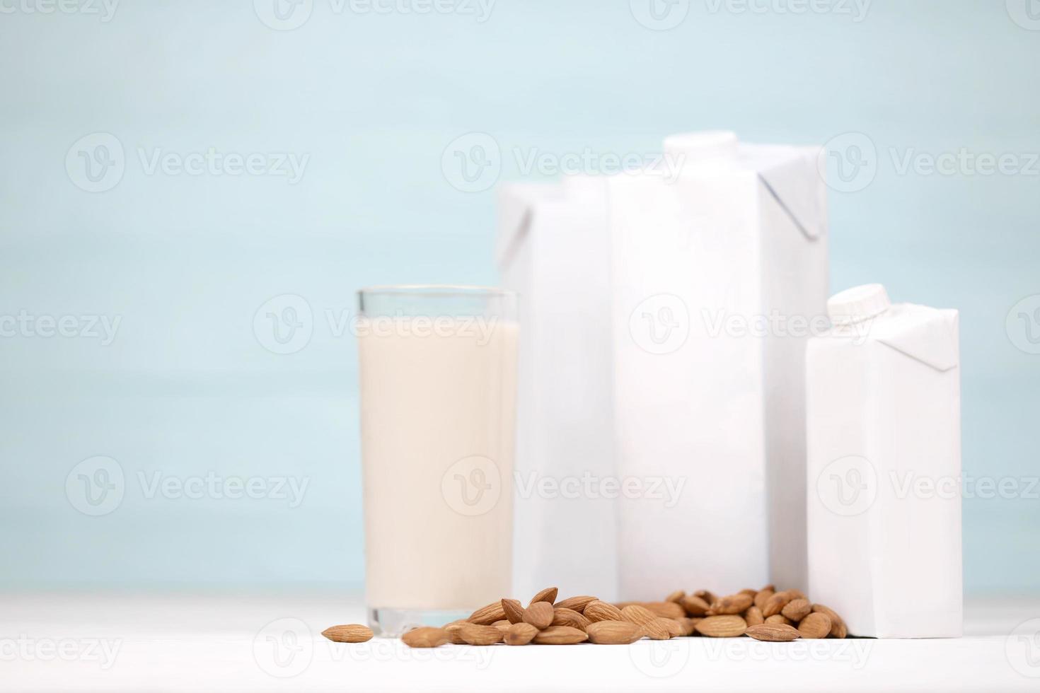 Glass of almond milk with almond nuts on canvas fabric on white wooden table. Dairy alternative milk for detox, healthy eating and diets photo