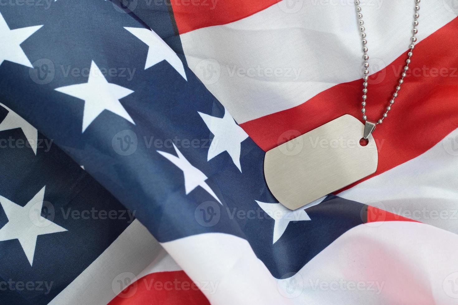 Silvery military beads with dog tag on United States fabric flag photo