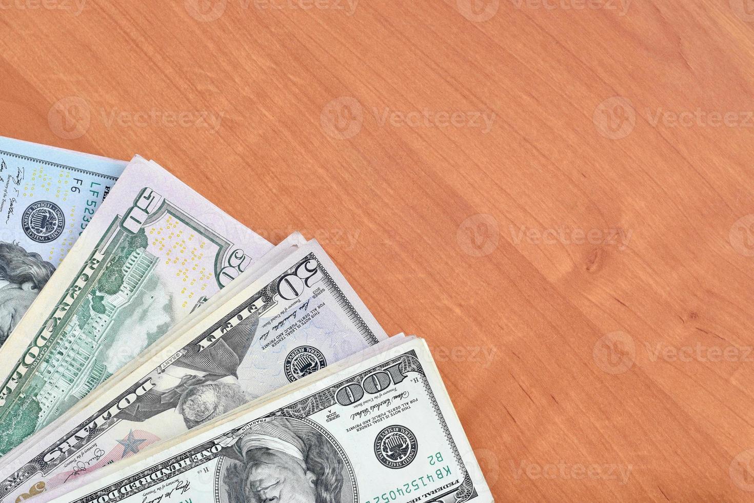 Stacks of many one hundred and fifty dollar bills on wooden background surface close up. Flat lay top view. Abstract business concept photo