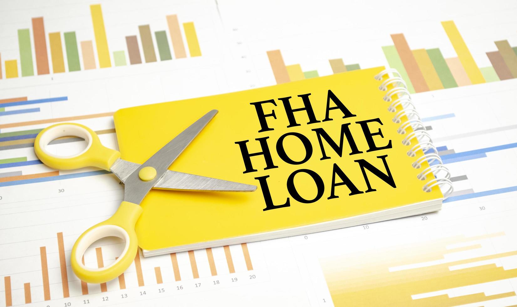 words FHA Home loan on notepad and pen, glasses on wooden background photo