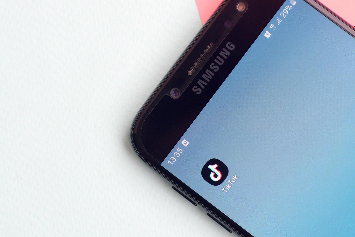Tiktok application on samsung smartphone screen on pastel background. TikTok is a popular video-sharing social networking service owned by ByteDance photo