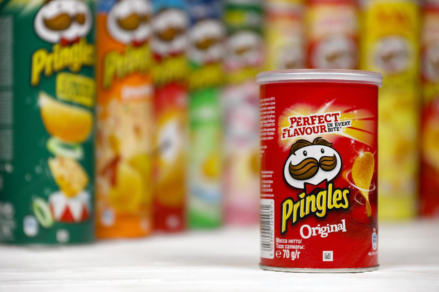 Pringles variety of flavors. Many cardboard tube cans with Pringles potato chips. Pringles is a brand of potato snack chips owned by the Kellogg Company photo