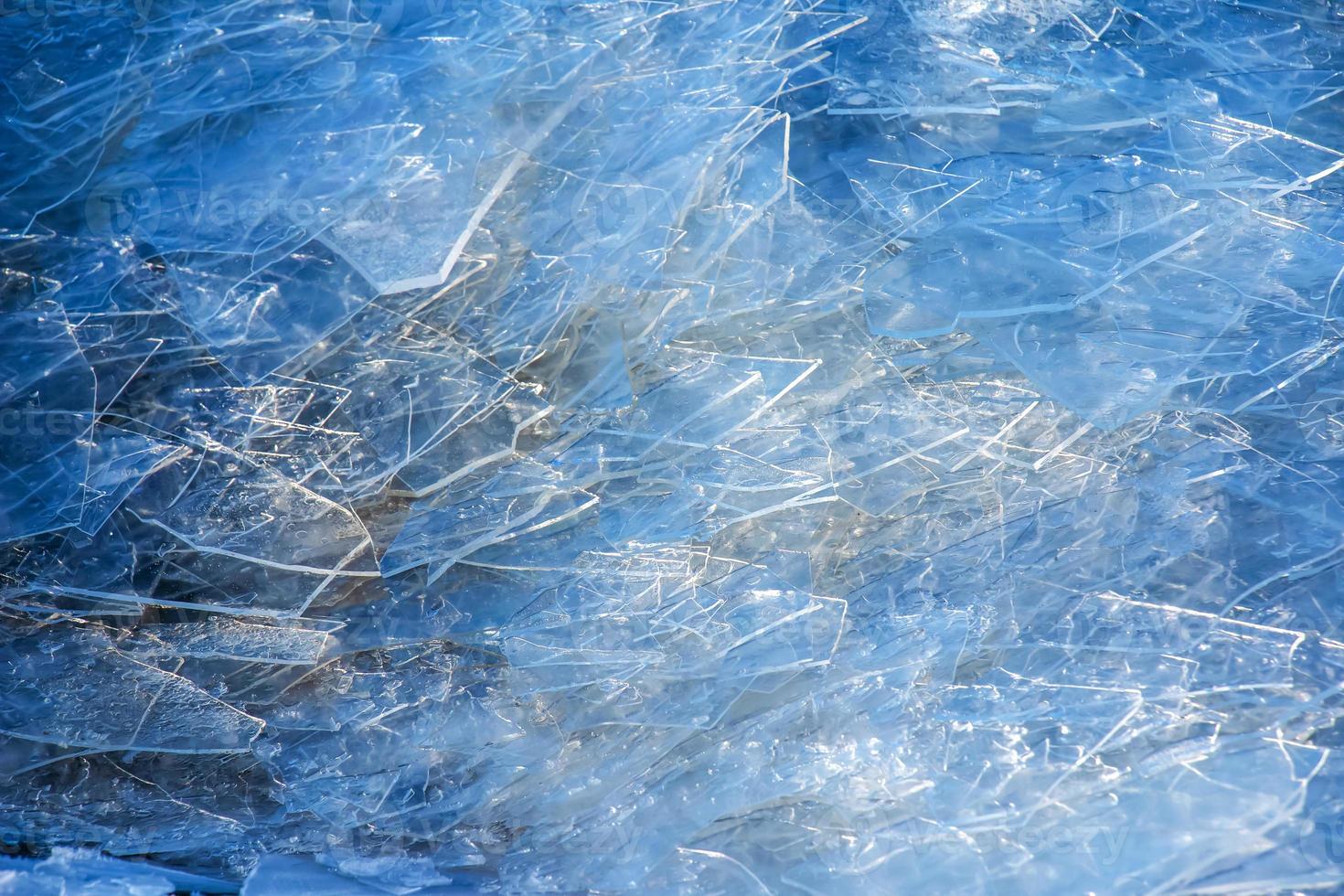 Winter background of the icy surface of the river. Texture of ice covered with snow. photo