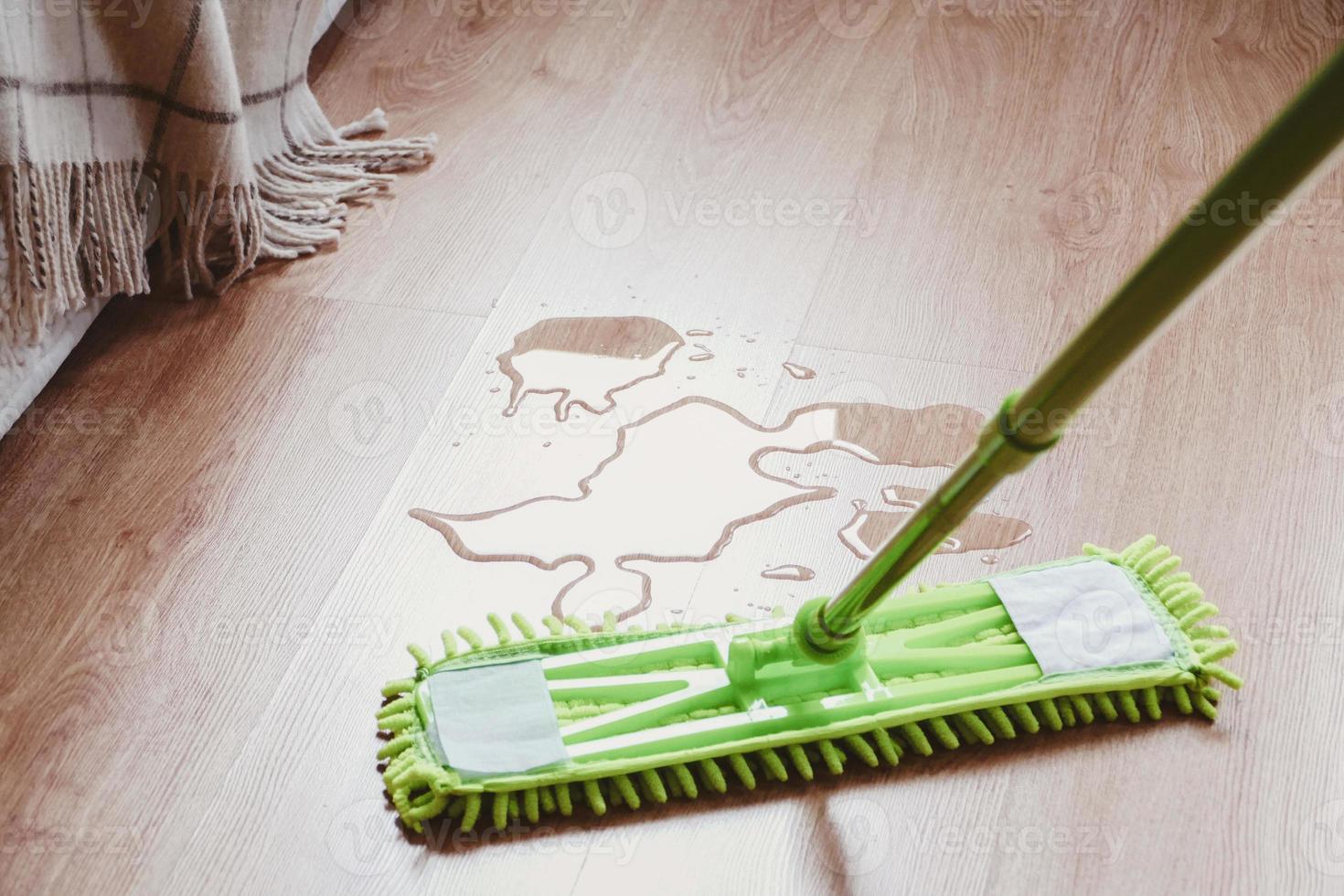 Water on the laminated wooden floor in bedroom, mop wiping wet floor photo