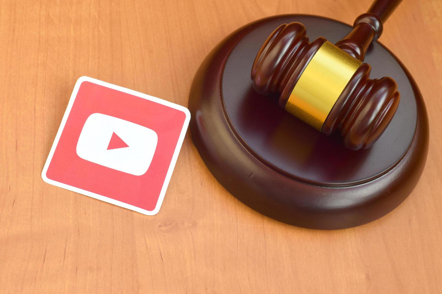 Youtube paper logo lies with wooden judge gavel. Entertainment lawsuit concept photo