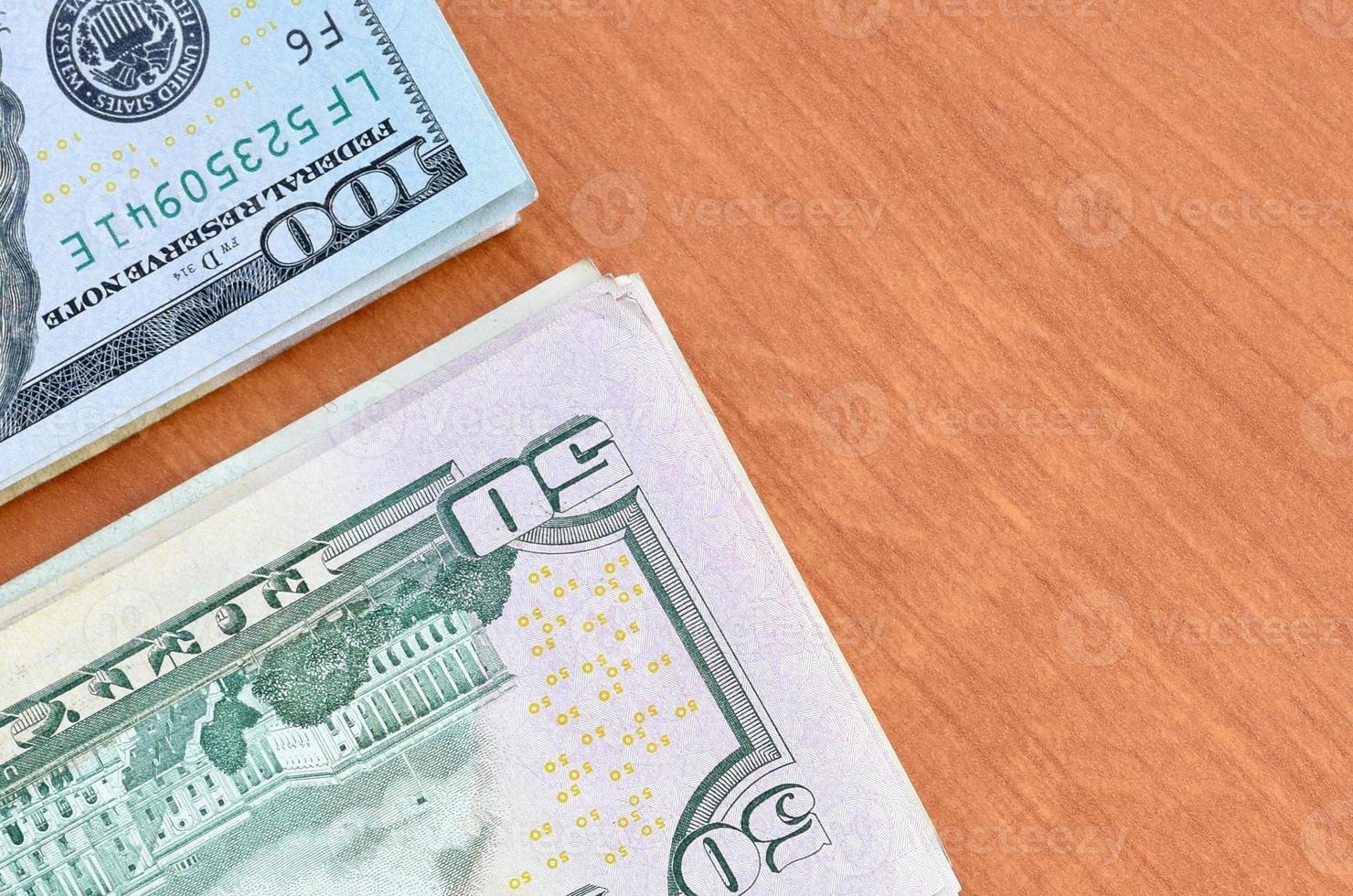 Stacks of many one hundred and fifty dollar bills on wooden background surface close up. Flat lay top view. Abstract business concept photo