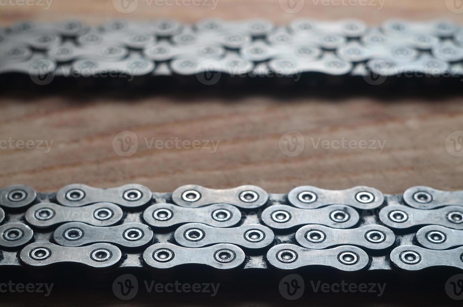 Dirty and oily chain from a mountain bike lying on a wooden table in a bicycle shop photo