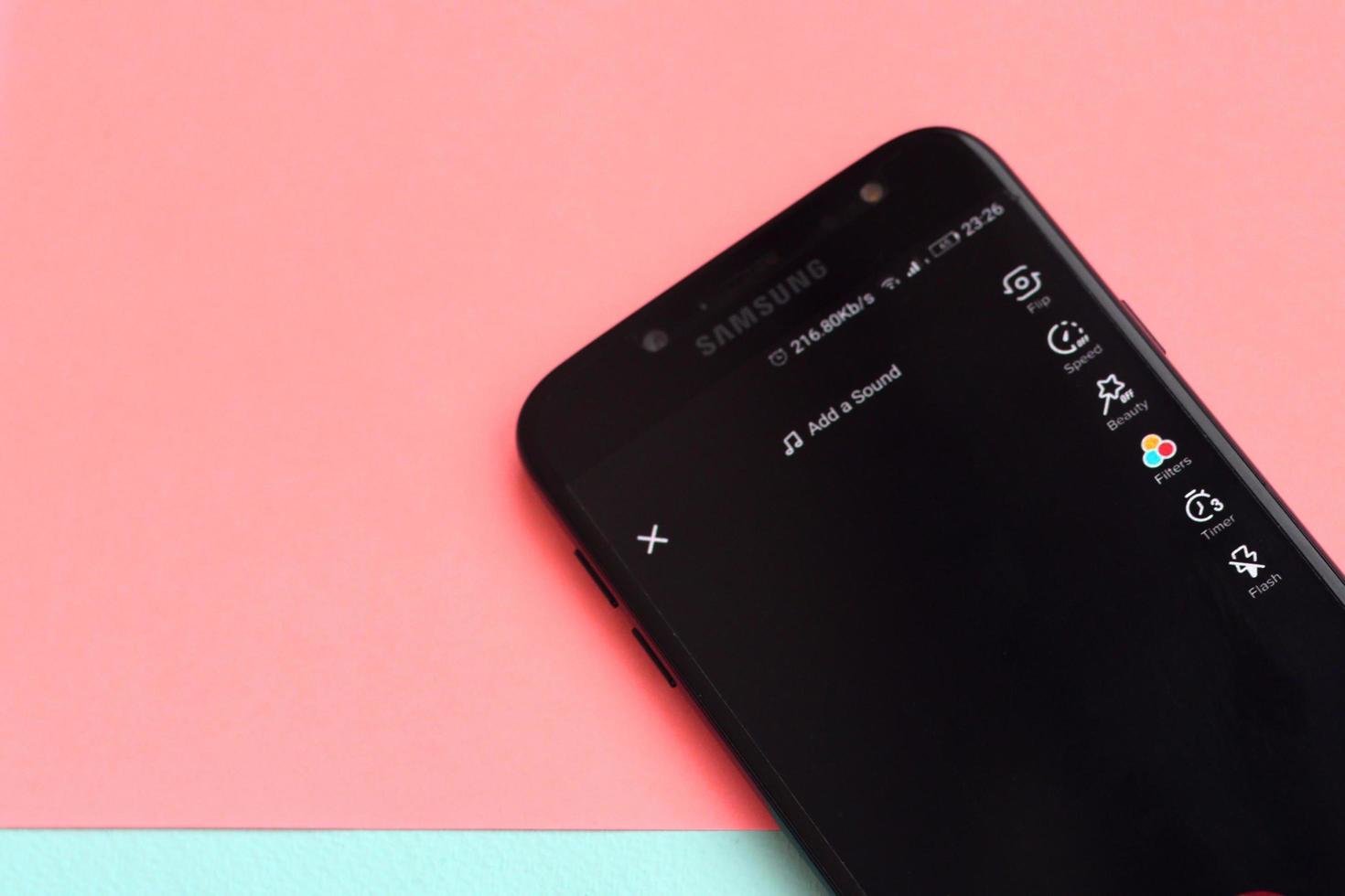 Tiktok application on samsung smartphone screen on pastel background. TikTok is a popular video-sharing social networking service owned by ByteDance photo