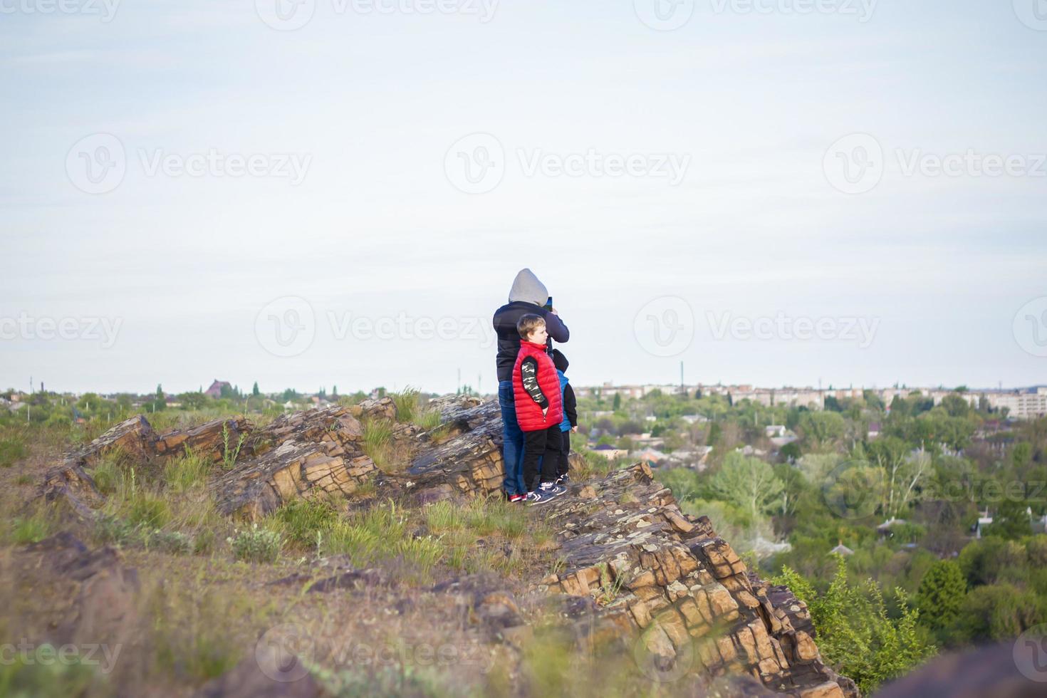 A man and children are standing on a rock and watching what is happening below. panoramic view from above. Russia, Rostov region, skelevataya skala, the 7th wonder of the Don world. photo