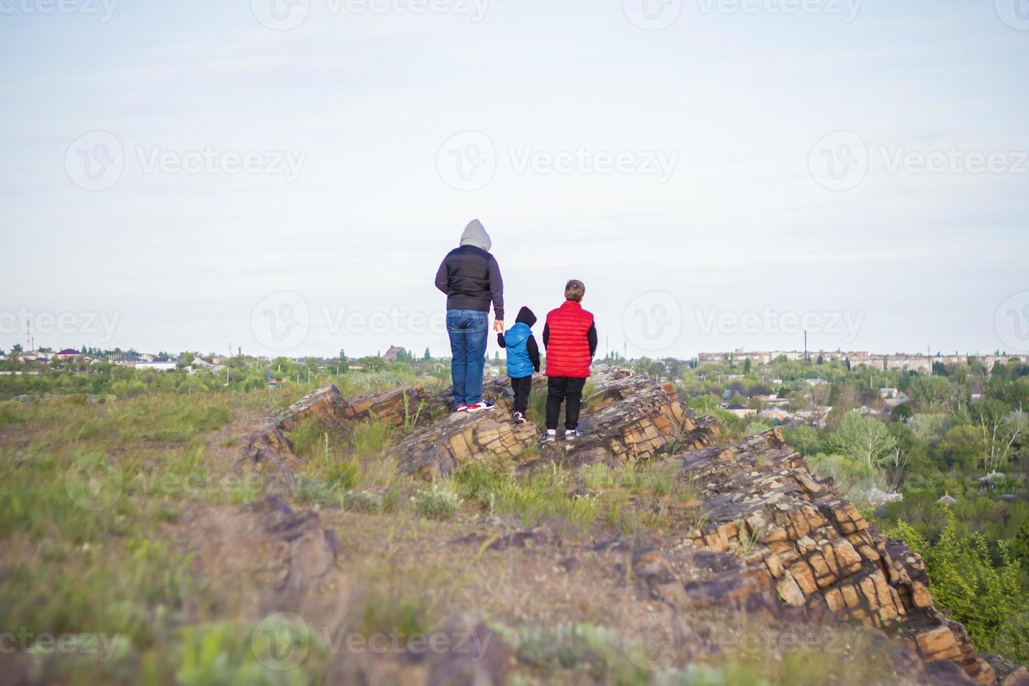 A man and children are standing on a rock and watching what is happening below. panoramic view from above. Russia, Rostov region, skelevataya skala, the 7th wonder of the Don world. photo