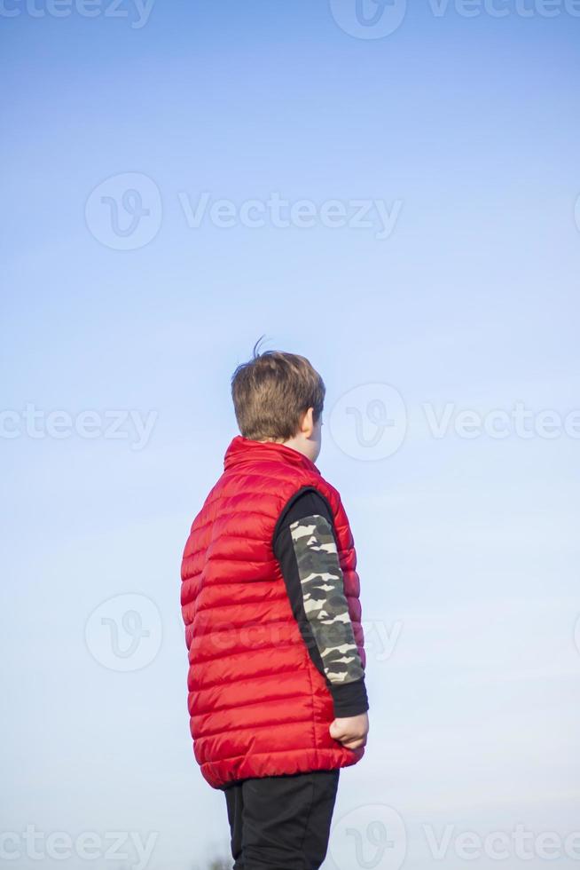 A child stands on top of a cliff and watches what is happening below. panoramic view from the top of a rocky mountain. Russia, Rostov region, skelevataya skala, the 7th wonder of the Don world. photo