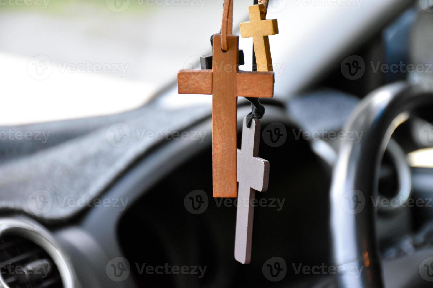 Necklaces of various shapes of crosses are hung in the rearview