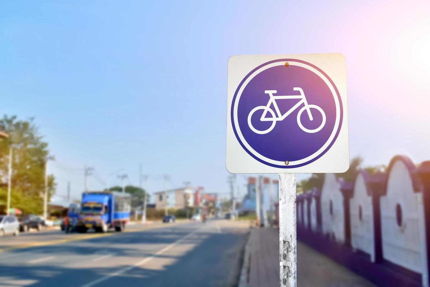 Bike path traffic sign on metal pole, soft and selective focus, blur main road background. photo