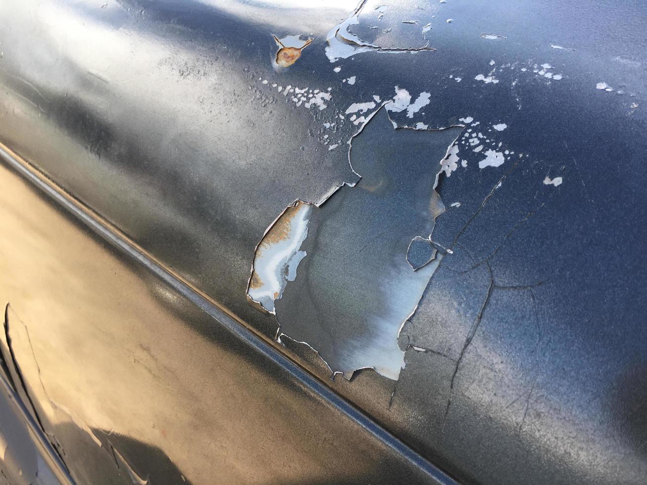 The paint sheet on the outside surface of the car is cracked into various shapes according to the condition and time of use of the car photo