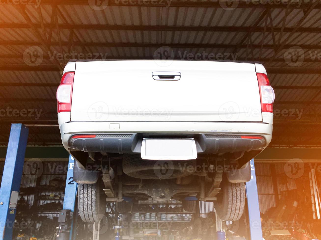 Rear of a pickup truck on a lift while being serviced at a garage, soft and selective focus. photo