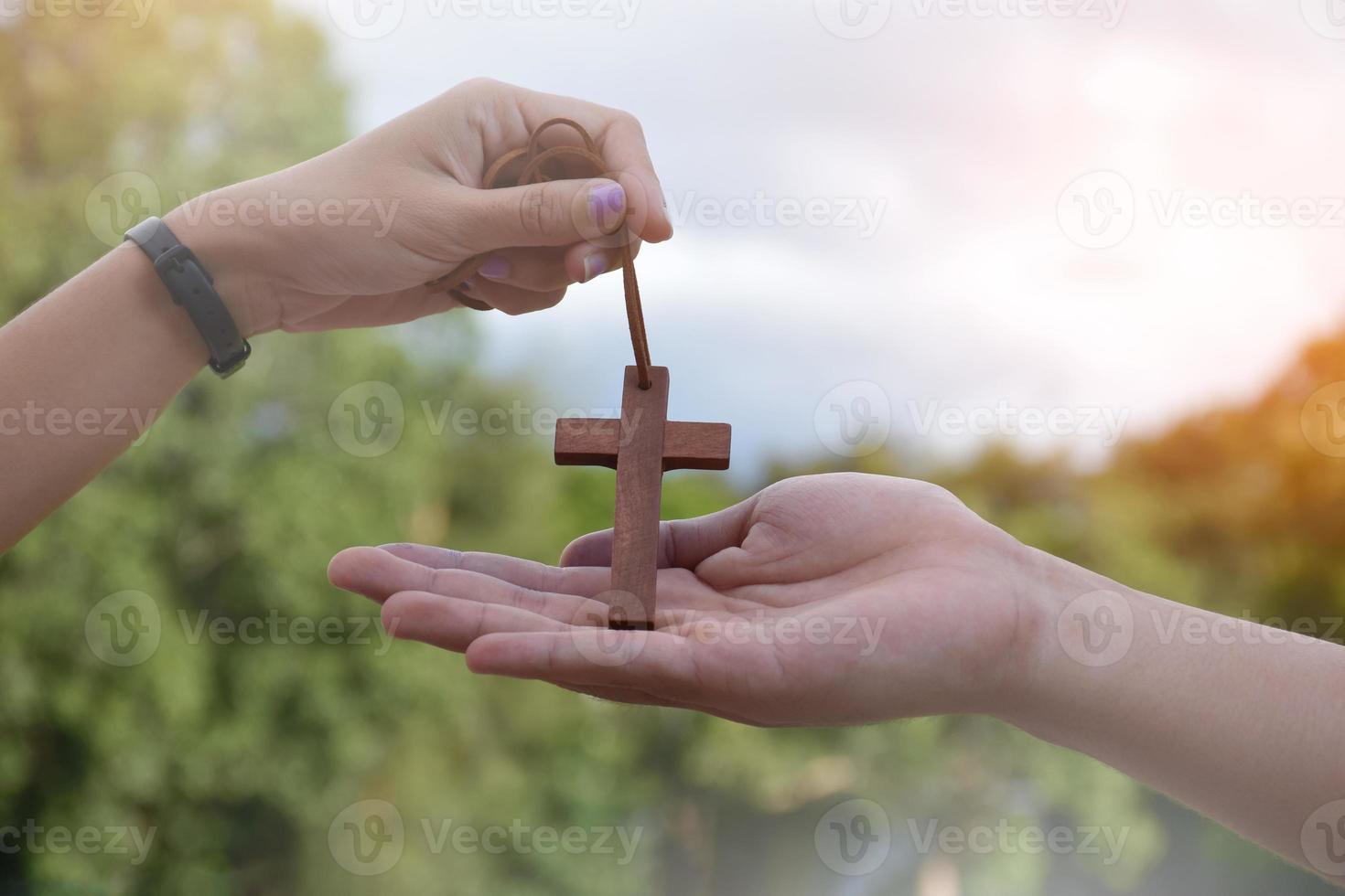 jóvenes cristianos asiáticos muestran y dan collares con una cruz a otras personas, enfoque suave y selectivo, concepto para mostrar orgullo de ser cristianos a otras personas en todo el mundo. foto