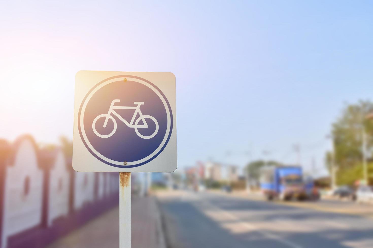 señal de tráfico de carril bici en poste de metal, enfoque suave y selectivo, desenfoque de fondo de la carretera principal. foto