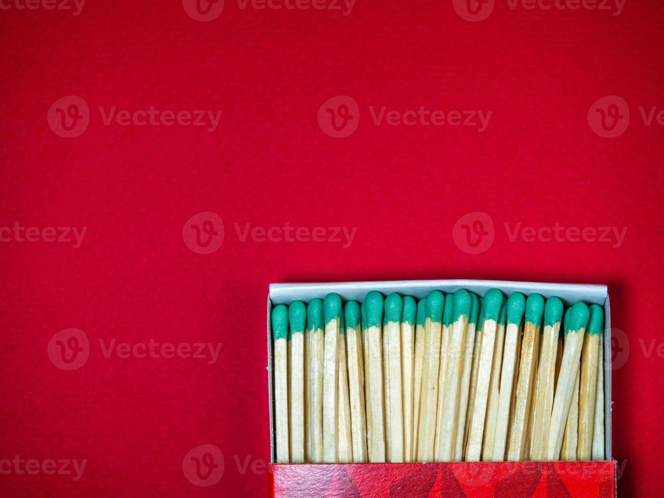 Large matches with green heads on a red background. photo