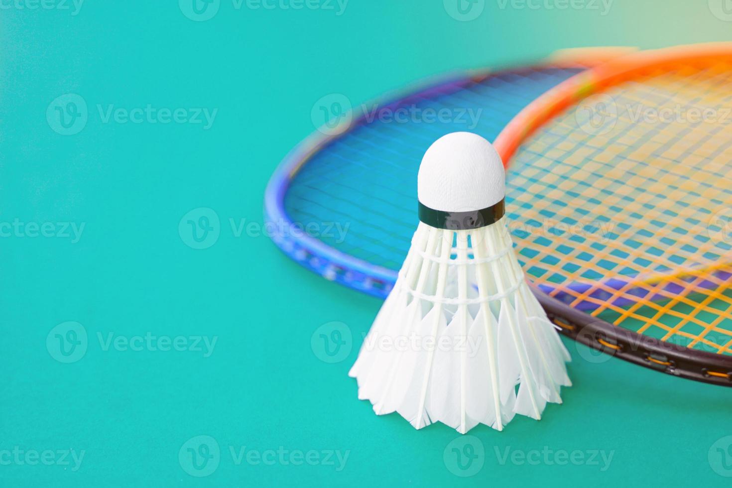 white shuttlecock on green background blurred badminton racket background. soft and selective focus. photo