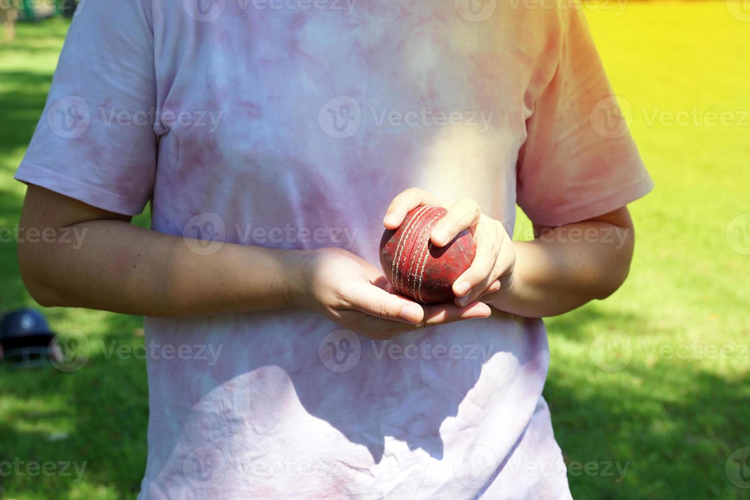 Asian female players hold clicket ball in hand while practicing for the first time on the grass field. photo