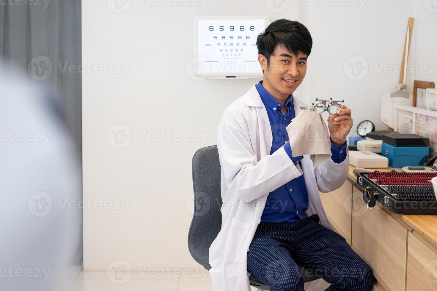 Selective focus at optometry trail frame. Asian Doctor optometrist using trail glasses equipment to examine eye sight visual system of patient to solve vision problem. photo