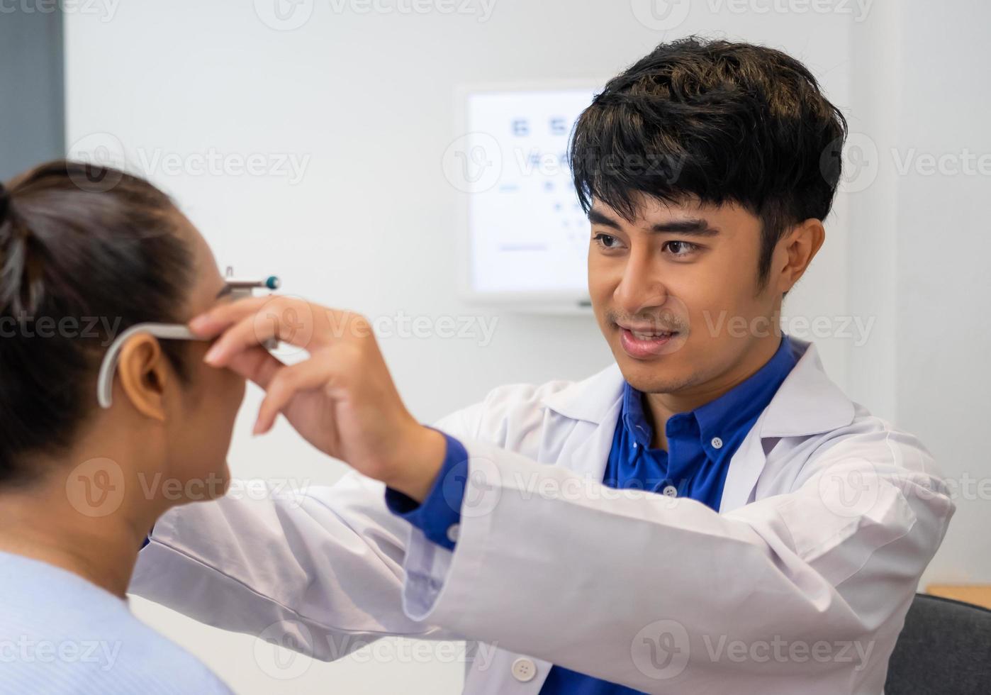 Selective focus at Optometrist face. While doctor using Optometry equipment and trial glasses frame  to examine eye visual system of elder patient women with professional machine and technic. photo