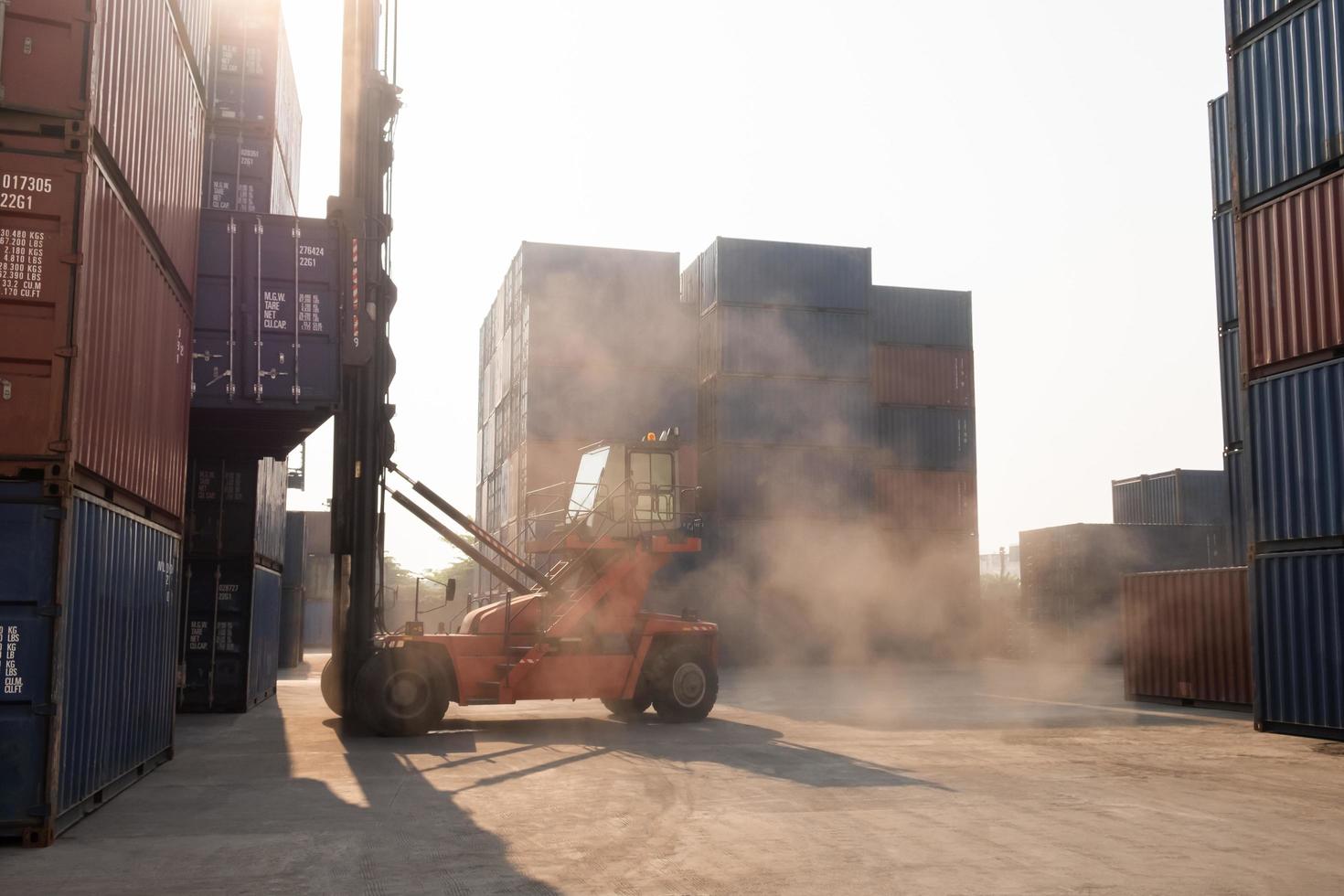 toma en movimiento del sitio de carga de contenedores industriales con una pila de muchos contenedores mientras la carretilla elevadora lo mueve para cargarlo, transportarlo y entregarlo a otro destino. actividad de importacion y exportacion foto