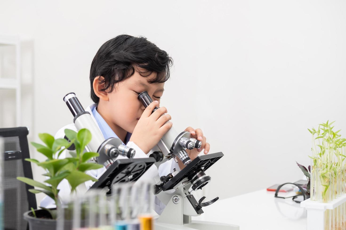 Selective focus at face. Young Asian boy and girl smile and having fun while doing science experiment in laboratory classroom with Teacher. Study with scientific equipment and tubes. Education concept photo