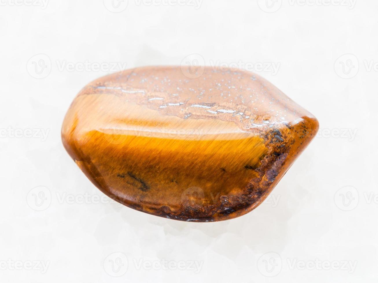 tumbled tiger's eye gemstone on white marble photo