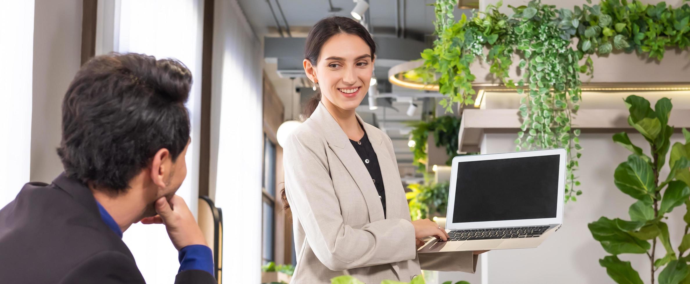 Selective focus at computer screen. Caucasian business women dress in formal suit holding laptop computer while meeting about work project to boss with smile and confident. Banner, indoor shot. photo