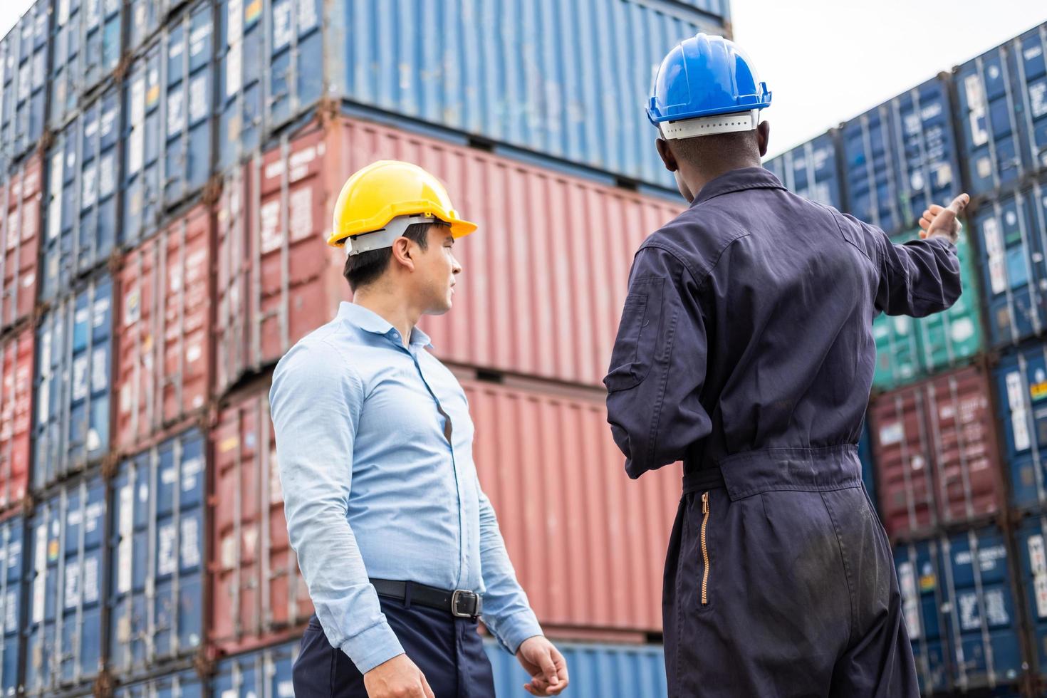 Selective focus at African black worker while talk and having discussion with supervisor and inspect the condition of all containers shipment, People and worker in freight deliver, import and export. photo