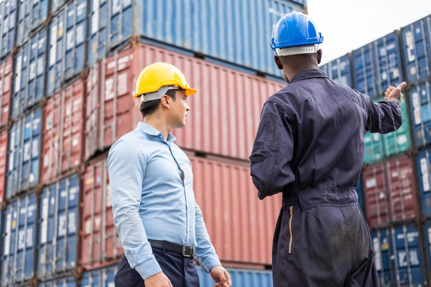 Selective focus at African black worker while talk and having discussion with supervisor and inspect the condition of all containers shipment, People and worker in freight deliver, import and export. photo