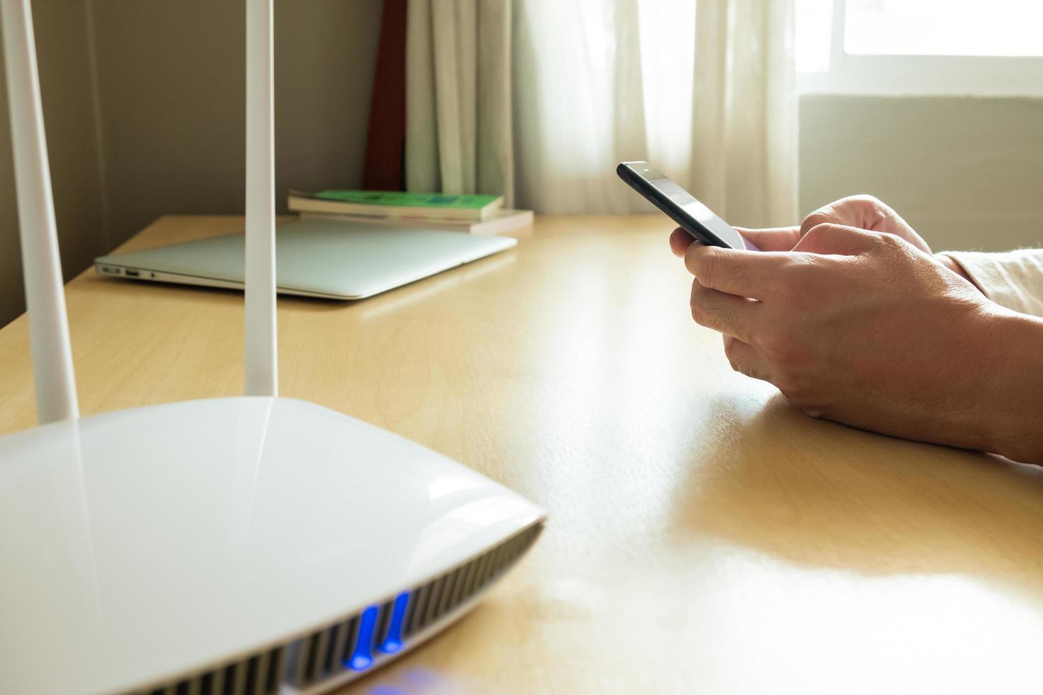 Men hand using smartphone device to connect to wifi network from internet router. Broadband high speed internet network technology for access to many application and services online. photo