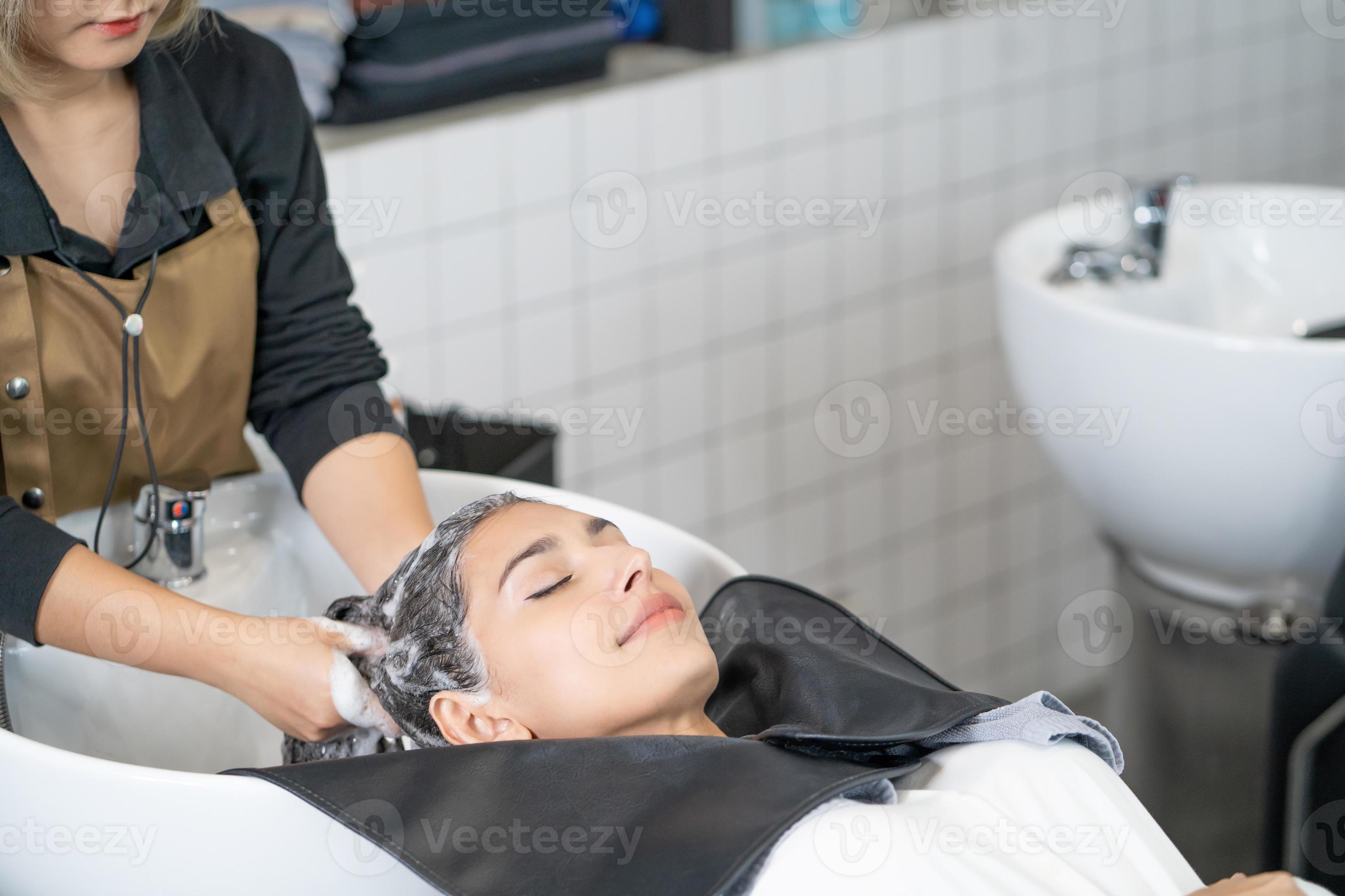 Beautiful Caucasian women feel relax and comfortable while getting hair wash  with shampoo and massage. Hair salon studio with hair stylish, beauty and  fashion concept. 13000425 Stock Photo at Vecteezy