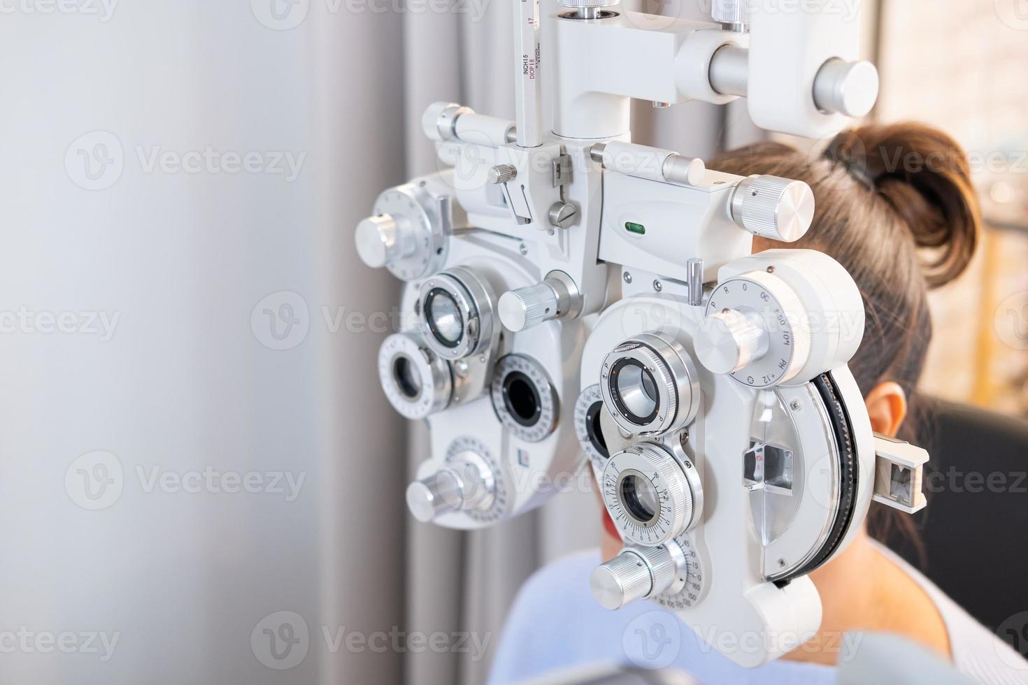 Selective focus at Optometry frame equipment. While doctor using penlight and subjective refraction to  examine eye visual system of elder patient women with professional machine before made glasses. photo