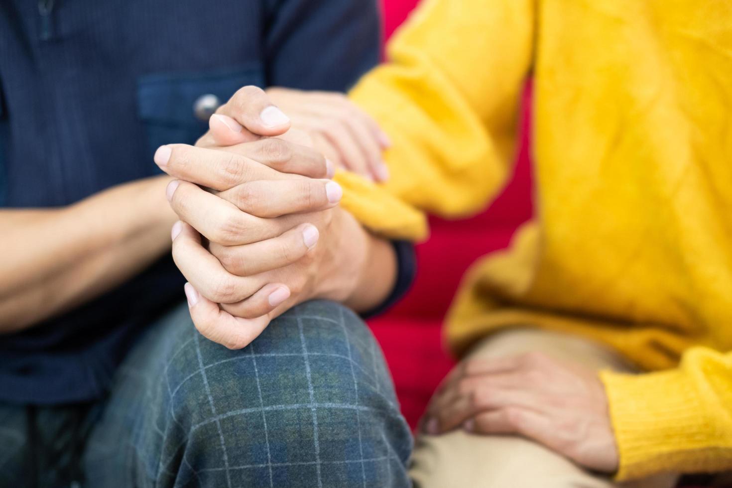 Selective focus at hands. Close up shot of young male homosexual or LGBT couple holding hands and embrace to show love expression. Same gender relationship, love and affection concept. photo