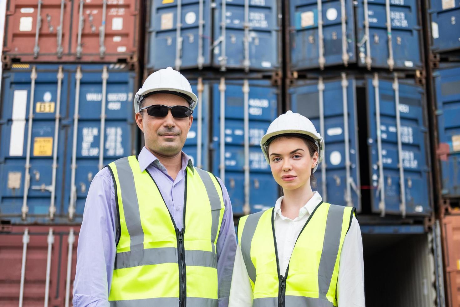 Caucasian men and women freight  supervisor wearing safety vest and hat while inspect condition of all containers shipment, People and worker in freight deliver, import and export. photo