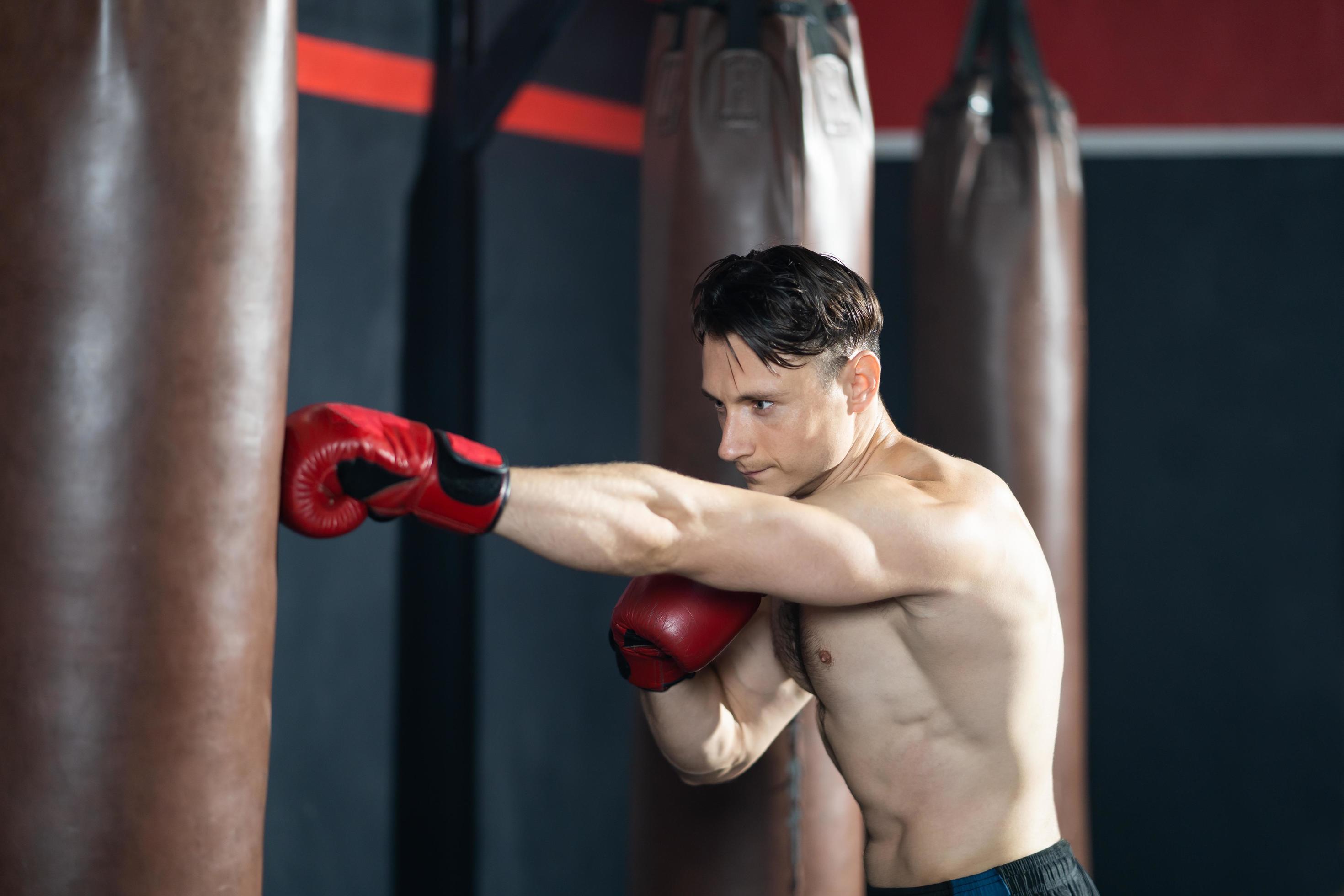 Guapo deportista muscular en ropa deportiva formación en cuadrilátero de  boxeo. Hombre Fuerte de hacer boxeo de sombra sobre rojo cuadrilátero de  boxeo en el gimnasio Fotografía de stock - Alamy