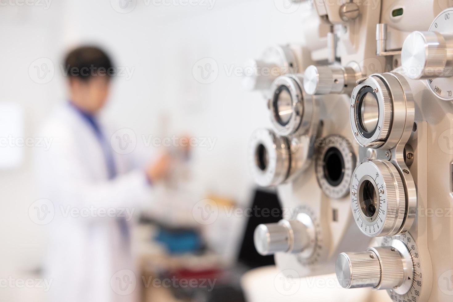 Selective focus at Optometry frame equipment. With blurred background while optometrist examine eye visual system of elder patient women with professional machine before made glasses. photo