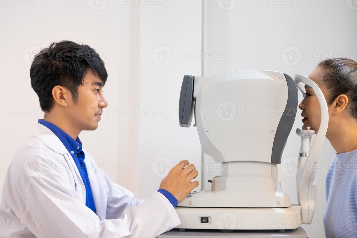 Selective focus at Optometry frame equipment. While doctor using penlight and subjective refraction to  examine eye visual system of elder patient women with professional machine before made glasses. photo