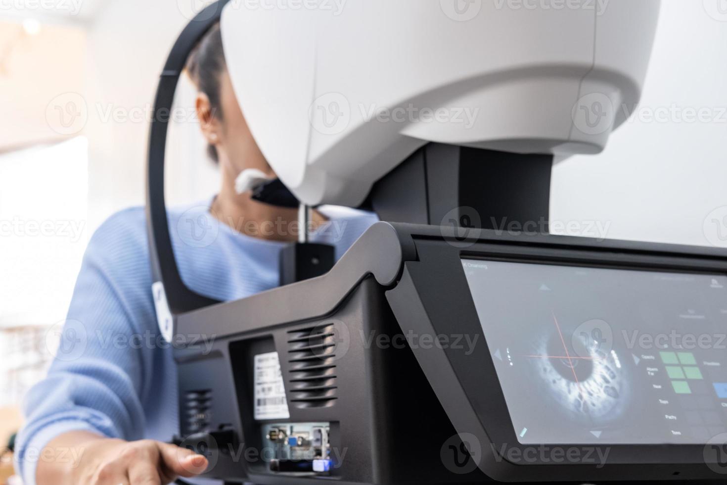 Selective focus at Optometry frame equipment. While doctor using penlight and subjective refraction to  examine eye visual system of elder patient women with professional machine before made glasses. photo