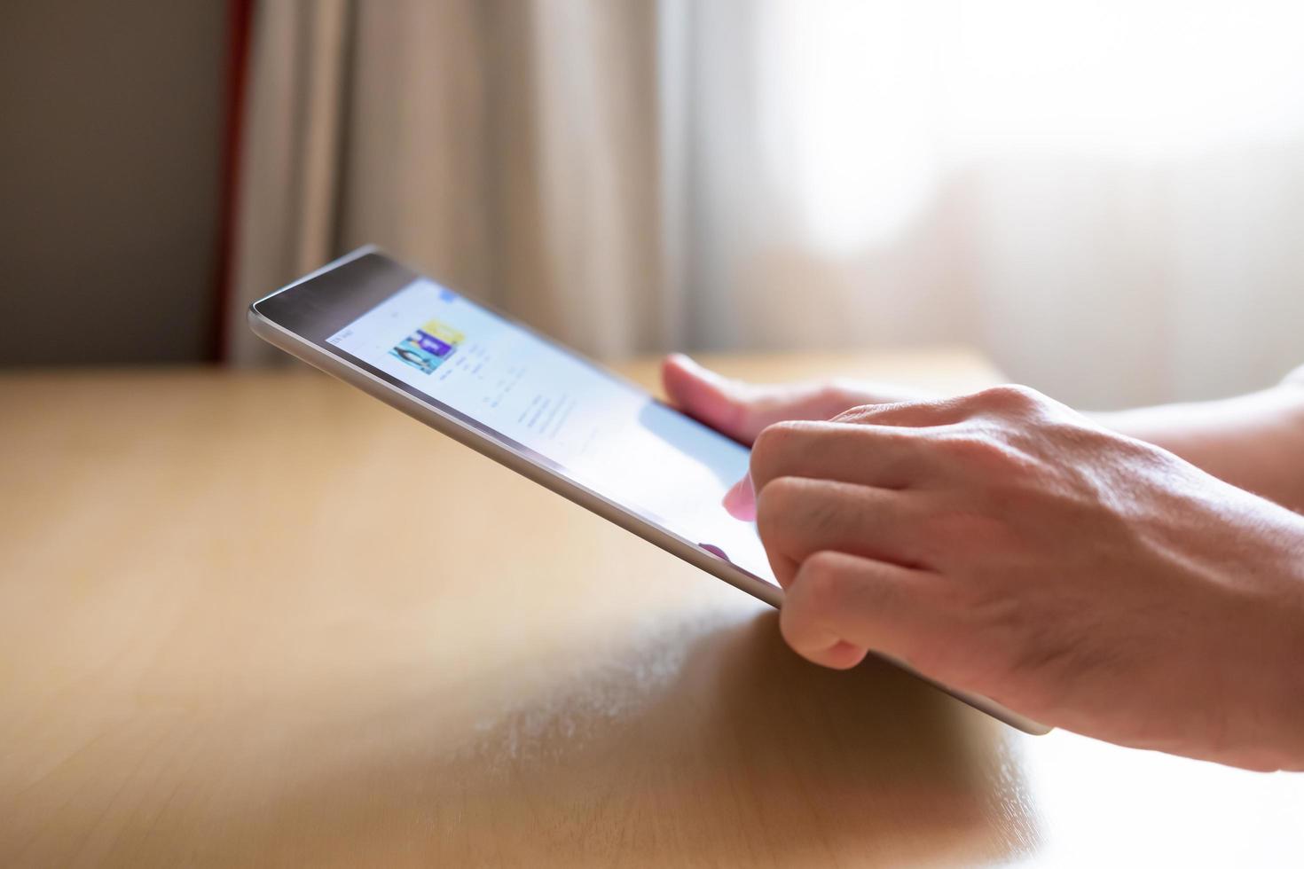 Selective focus at the edge of tablet. Men hand pressing the screen of smartphone tablet while search or browsing internet for reading news or information. Communication technology with copy space. photo