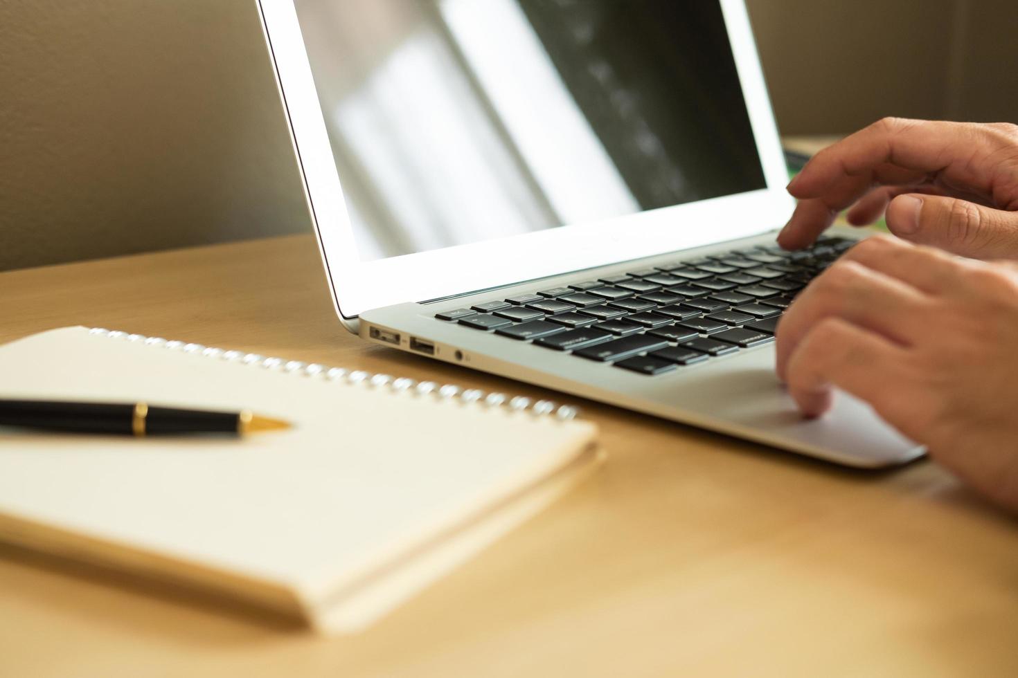 enfoque selectivo en el teclado de la computadora. los hombres asiáticos escriben a mano y estudian clases de aprendizaje en línea en casa. concepto de distancia social nuevo estilo de vida normal en el que las personas pueden trabajar o estudiar en casa. foto