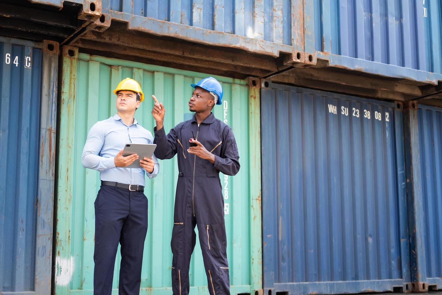 Selective focus at African black worker while talk and having discussion with supervisor and inspect the condition of all containers shipment, People and worker in freight deliver, import and export. photo