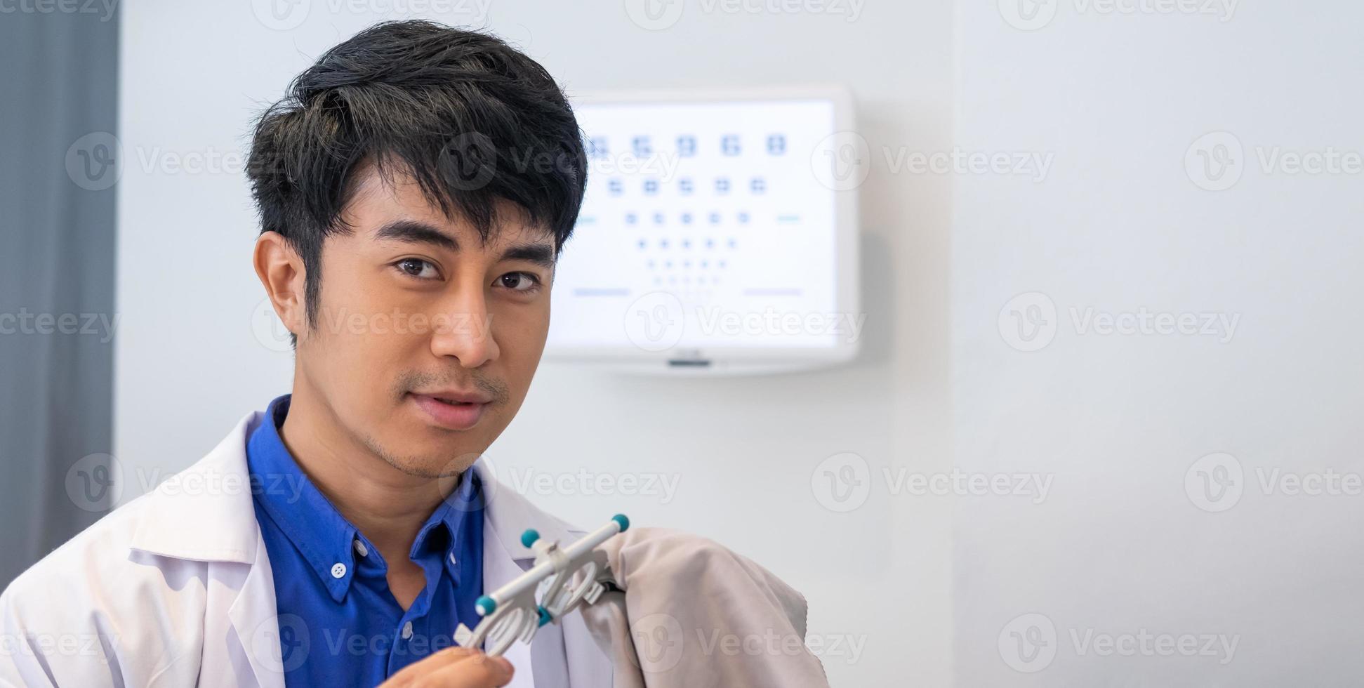Selective focus at optometrist face. Asian Doctor optometrist using trail glasses equipment to examine eye sight visual system of patient to solve vision problem. Healthcare and medical, banner shot. photo