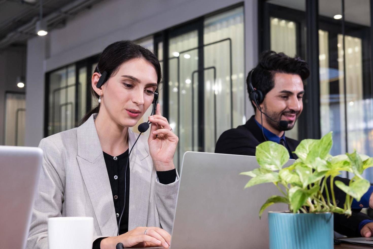 primer plano de hermosas mujeres de negocios caucásicas con traje formal. usando auriculares con micrófono mientras atiende la llamada telefónica para obtener asistencia de servicio al cliente. concepto de centro de llamadas. foto