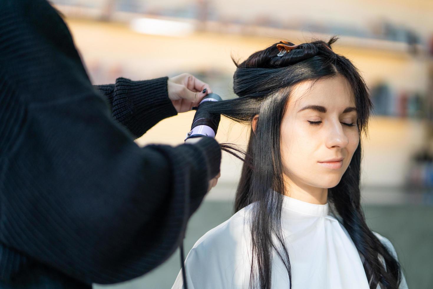 mujeres caucásicas con cabello elegante mientras se cortan el cabello y usan mascarilla quirúrgica mientras peinan el cabello para el cliente. ocupación profesional, servicio de belleza y moda nueva normalidad. foto