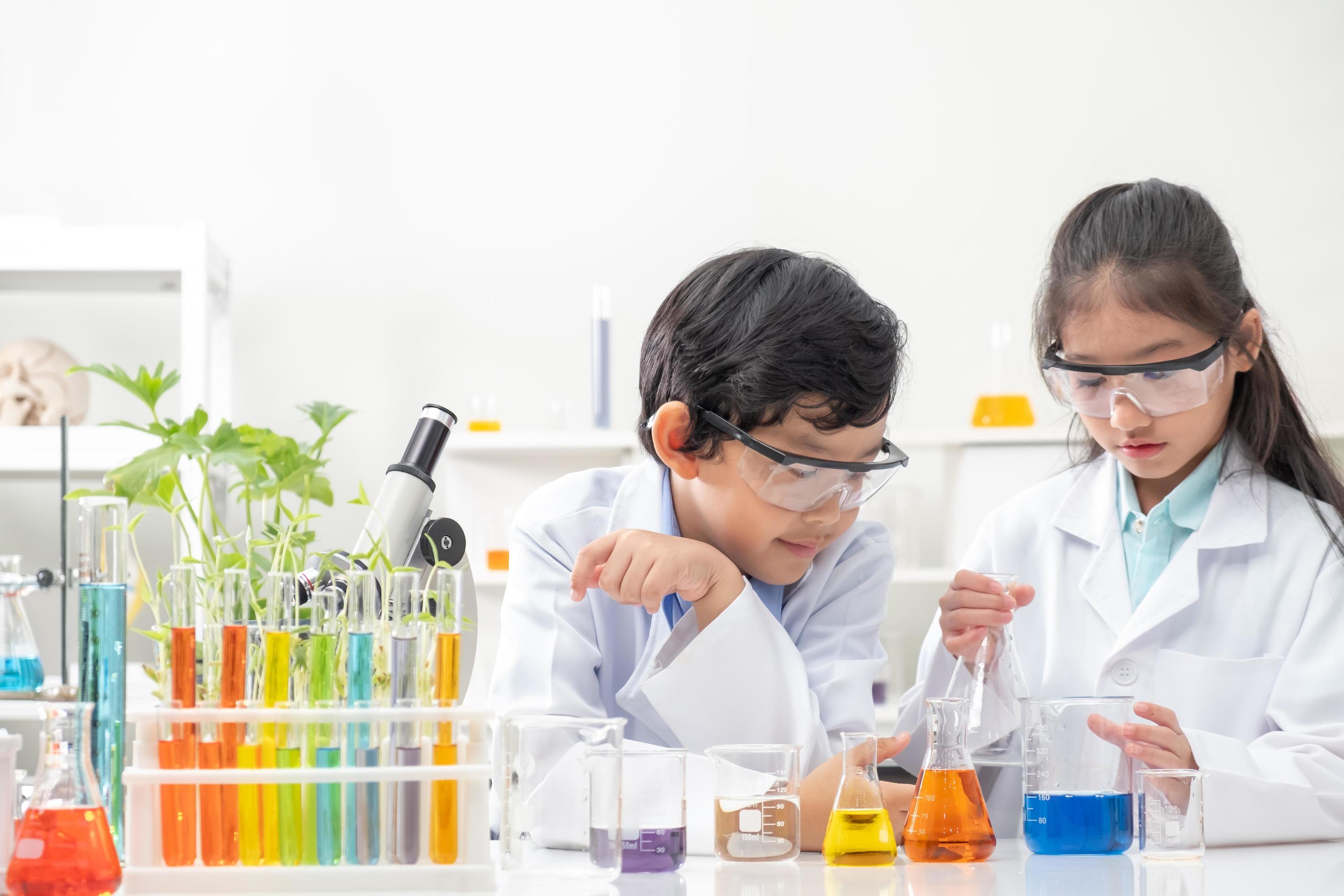 Young Asian boy and girl smile and having fun while doing science ...