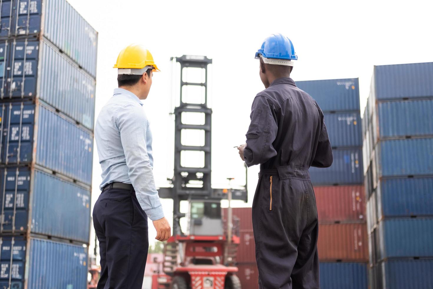 Selective focus at African black worker while talk and having discussion with supervisor and inspect the condition of all containers shipment, People and worker in freight deliver, import and export. photo